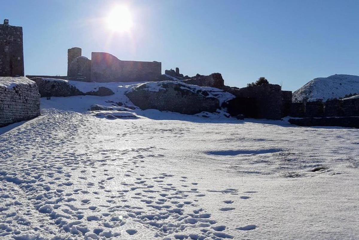a field covered in snow with the sun in the background