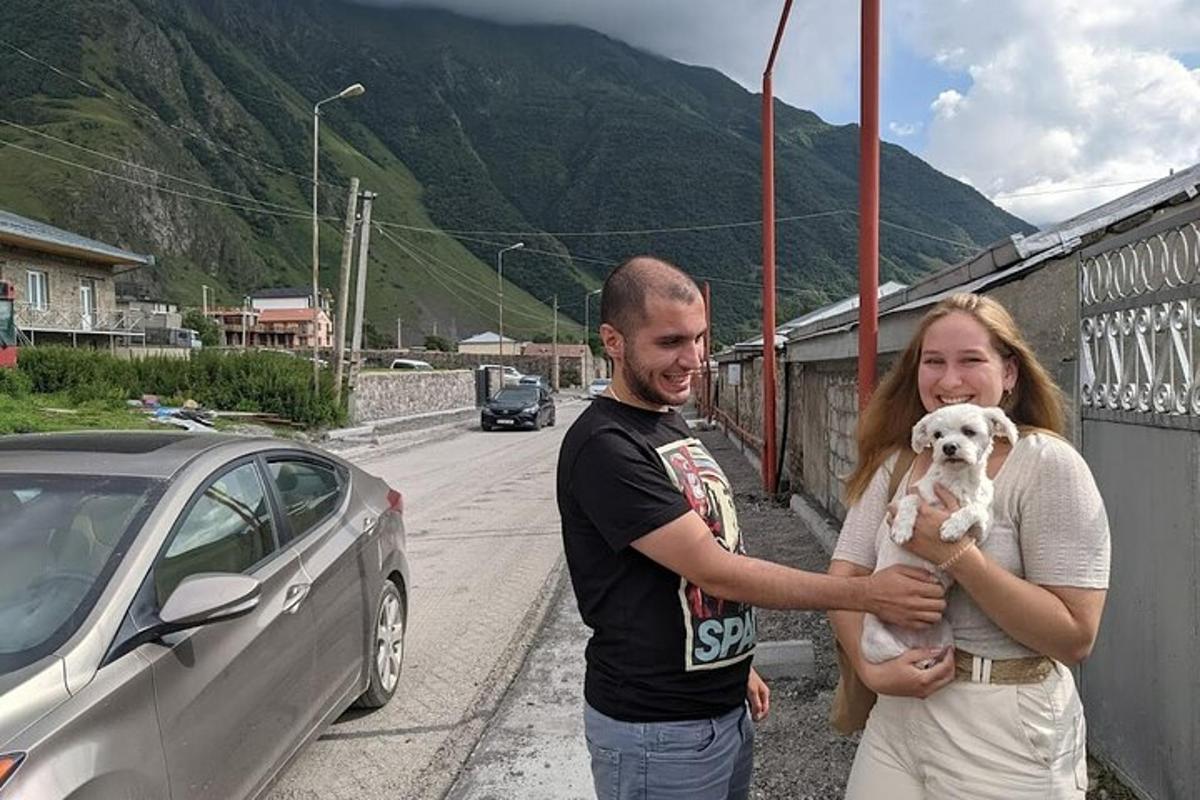 en mann og en kvinne som holder en hvit hund