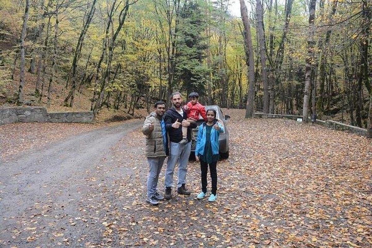 un gruppo di persone in piedi su una strada nel bosco