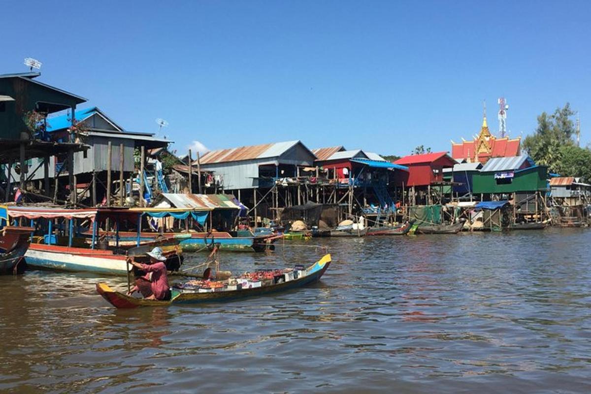 isang grupo ng mga bangka sa isang ilog na may mga bahay
