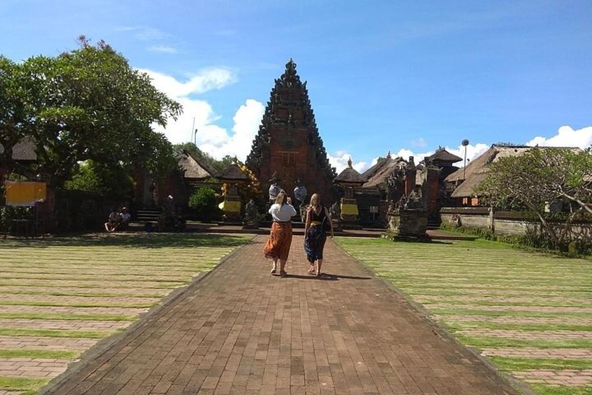 two women walking down a brick walkway in front of a building
