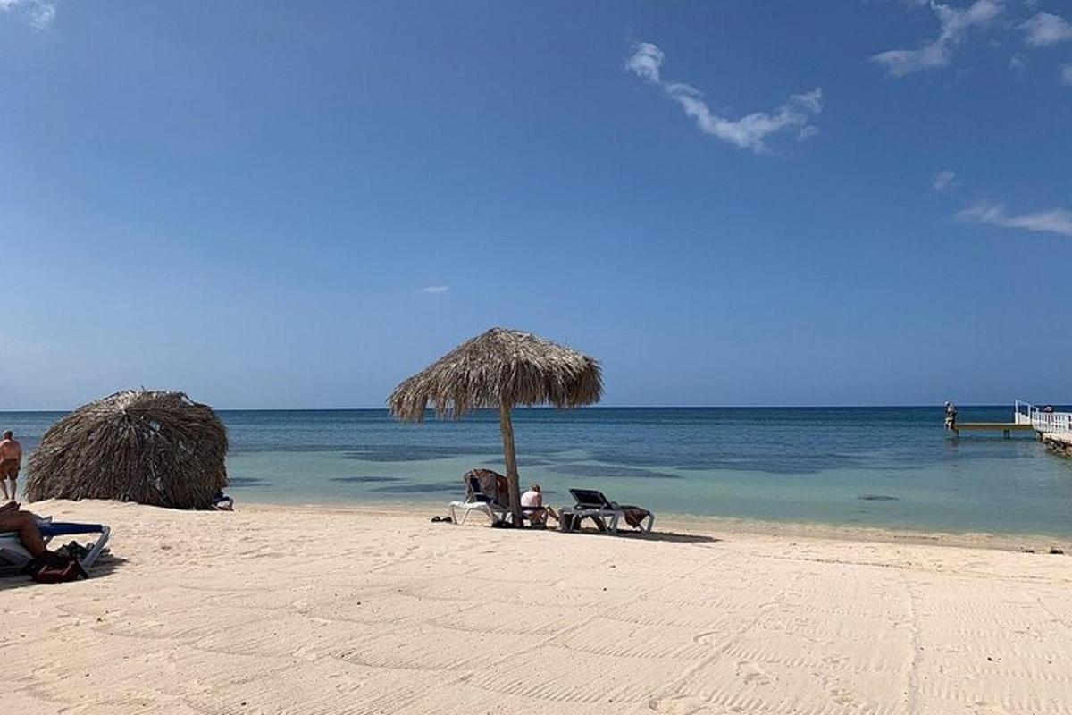 pantai dengan kerusi dan payung dan lautan