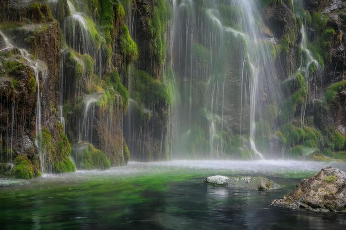 a waterfall with a rock in the water