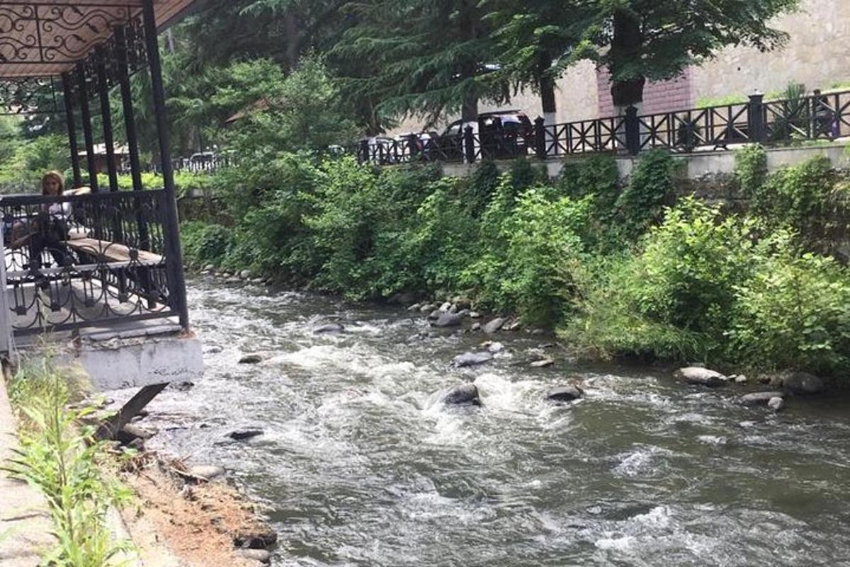 ein Fluss mit einer Gruppe von Menschen auf einer Brücke