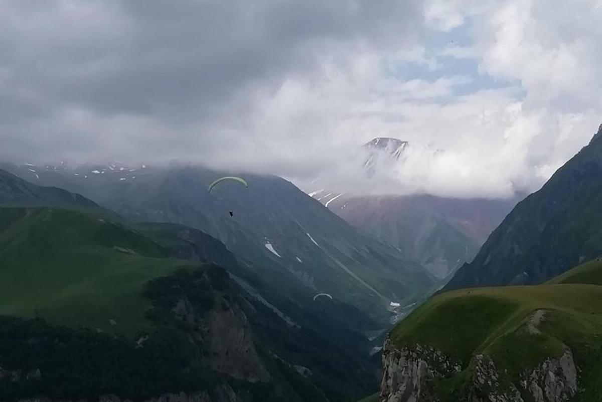 a person flying a kite in a mountain valley