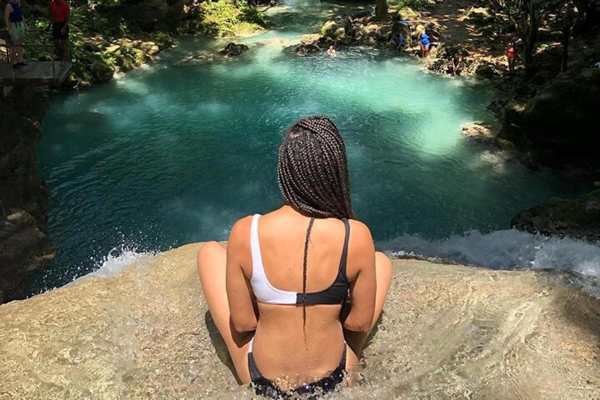 a woman in a bikini sitting in front of a body of water