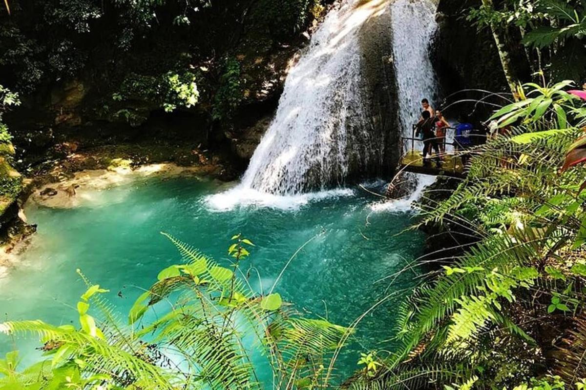 people standing on a bridge in front of a waterfall