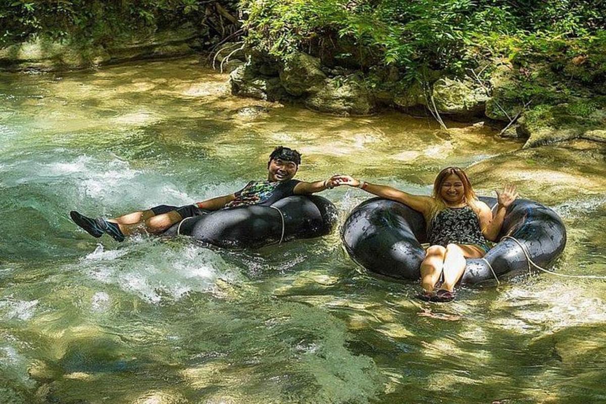 a man and a woman riding on elephants in the water