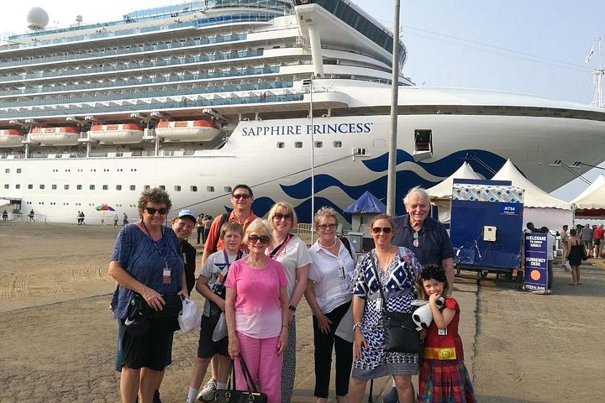 Un grupo de personas de pie frente a un crucero.