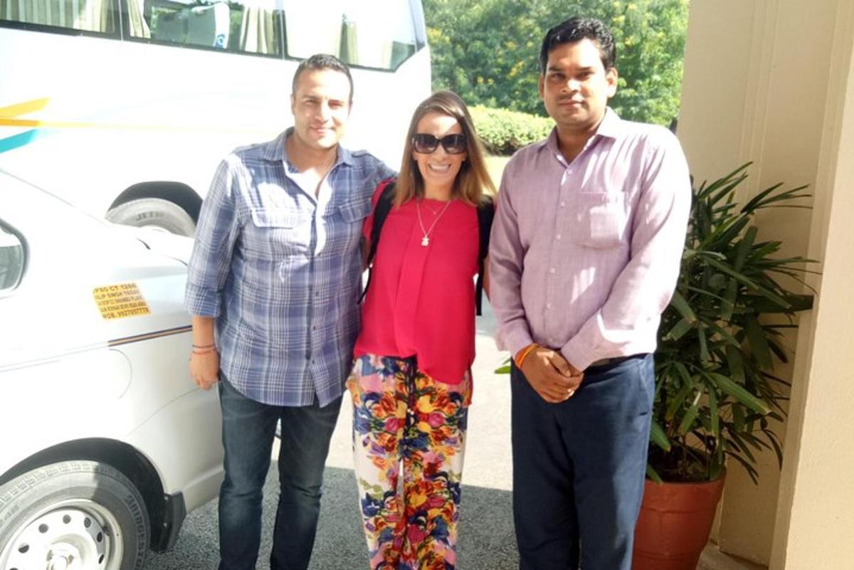 uma mulher e dois homens parados ao lado de uma van branca