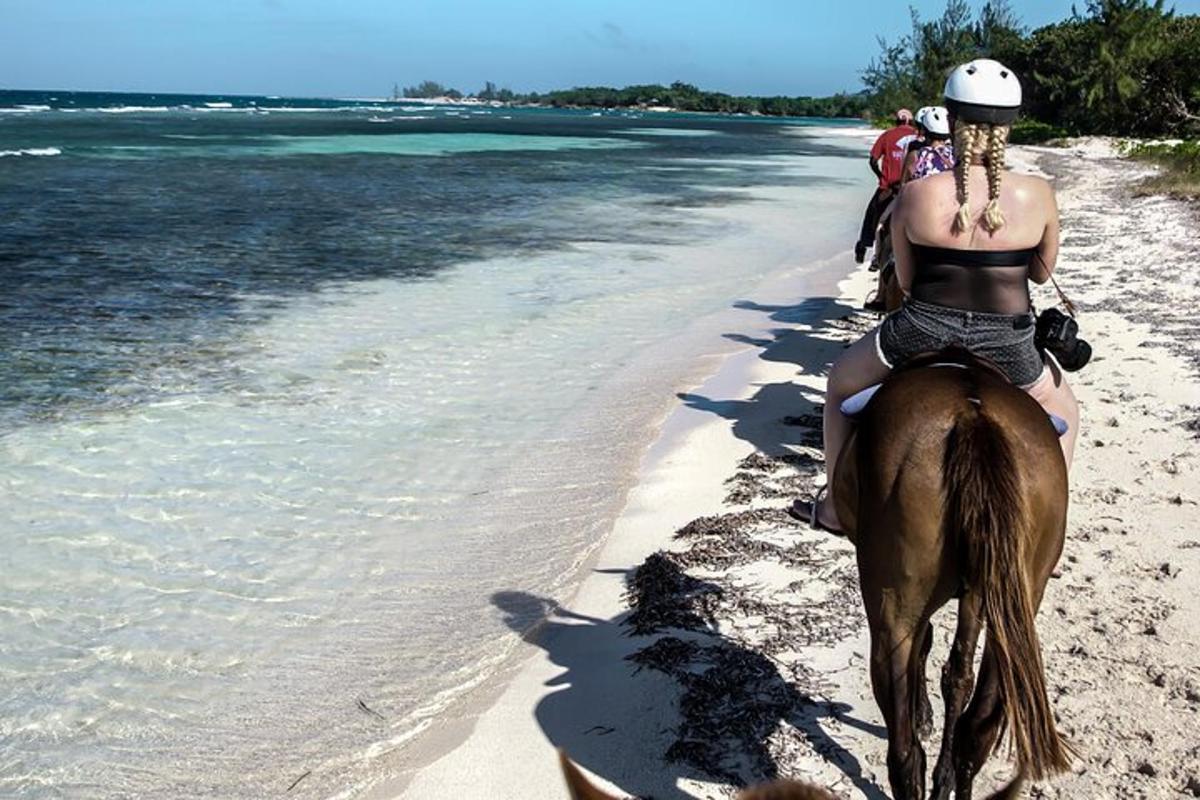 a woman riding a horse on the beach