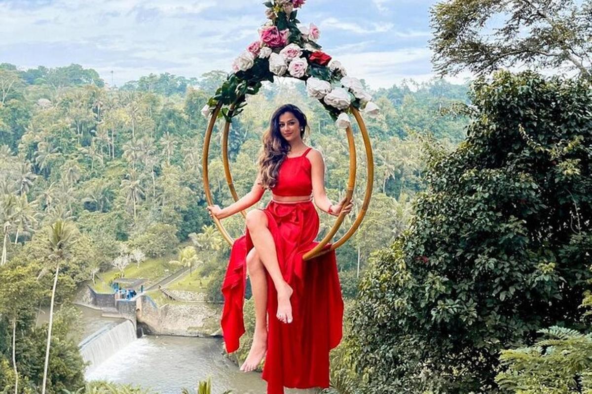 una donna in un vestito rosso seduta su un'altalena