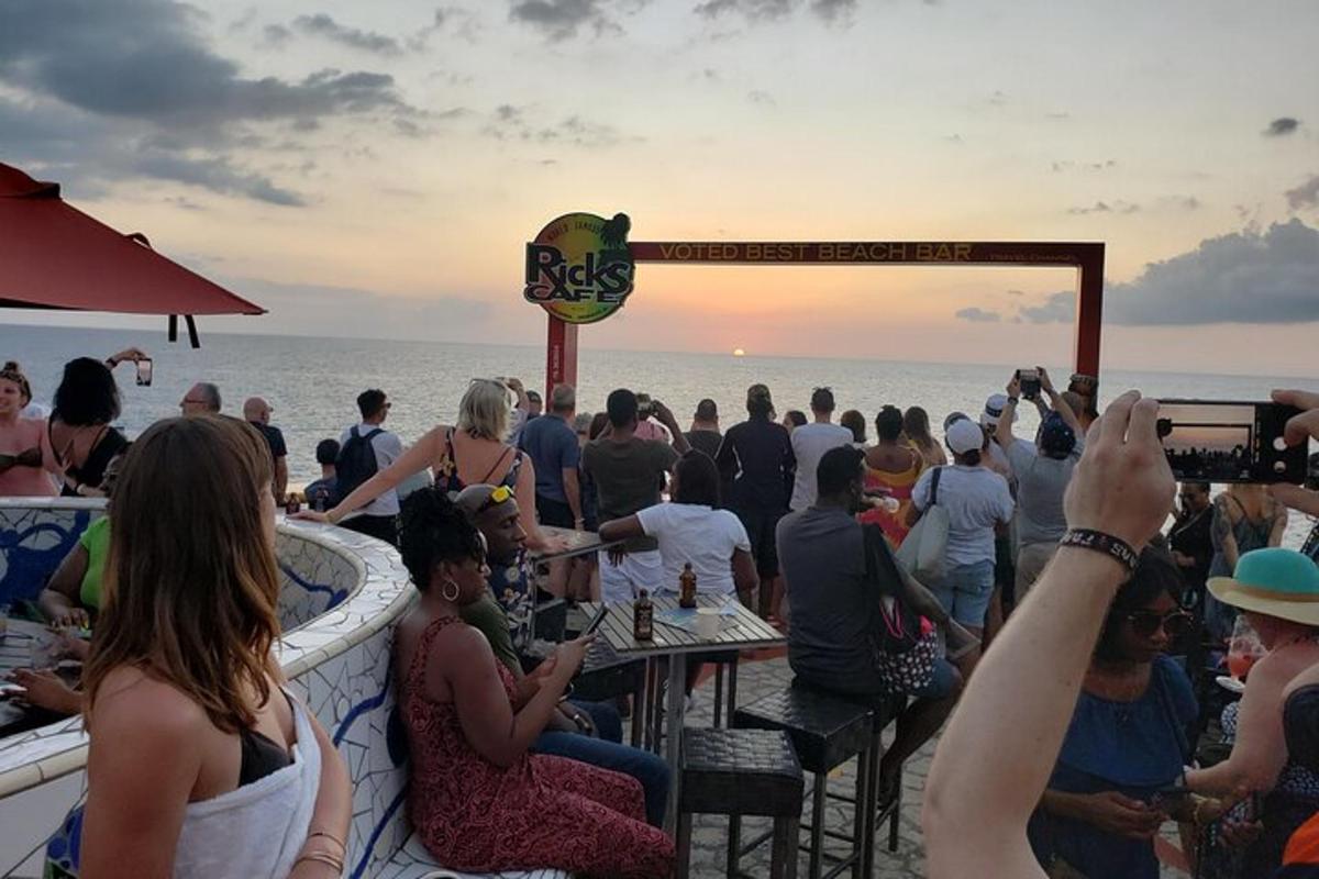 sekelompok orang duduk di bar di pantai