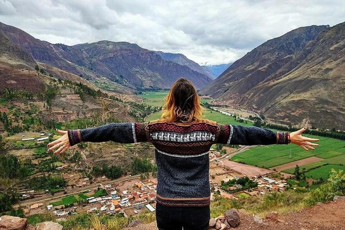 a woman standing on top of a mountain with her arms outstretched