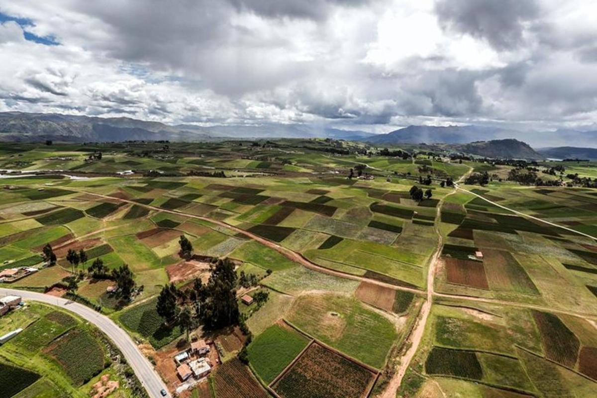 an aerial view of a field with mountains in the background