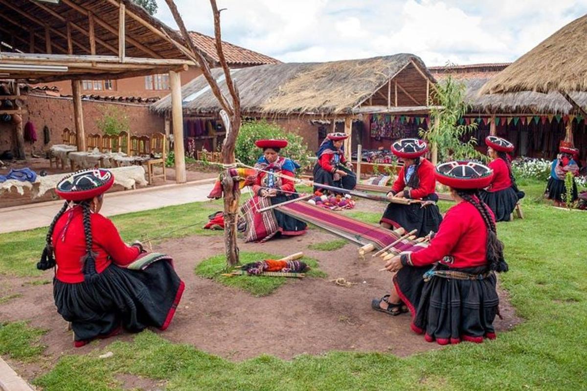 Un grupo de mujeres con ropa tradicional sentadas en el césped.