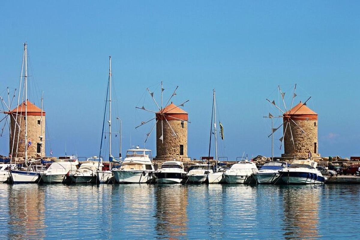 a group of boats parked in a harbor with windmills