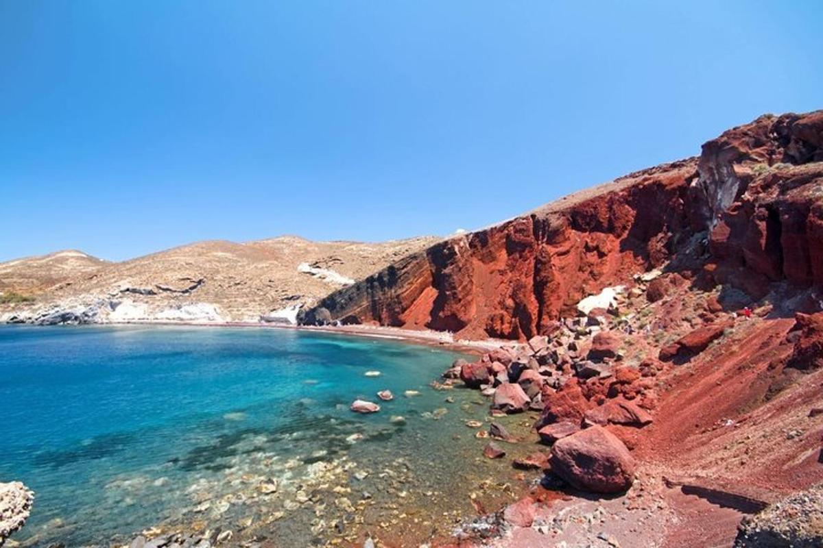 una playa con rocas rojas y agua azul