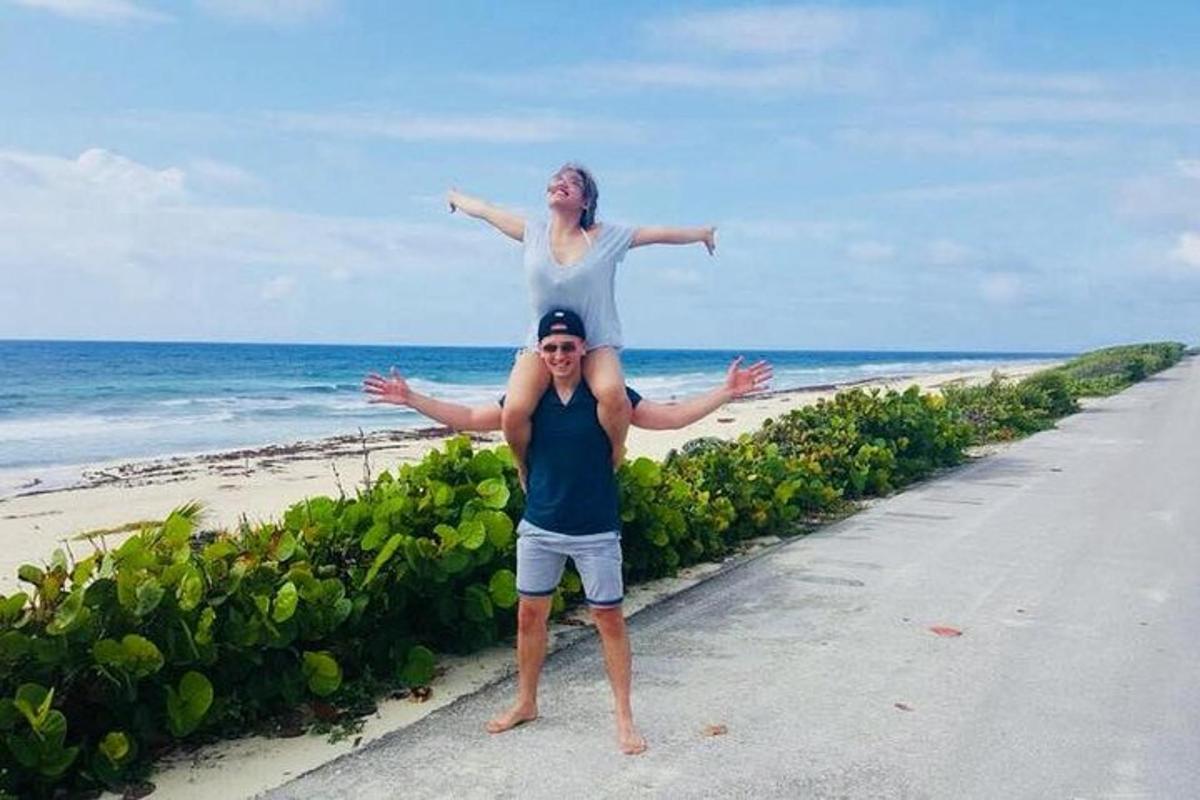 una donna in piedi sopra un uomo sulla spiaggia