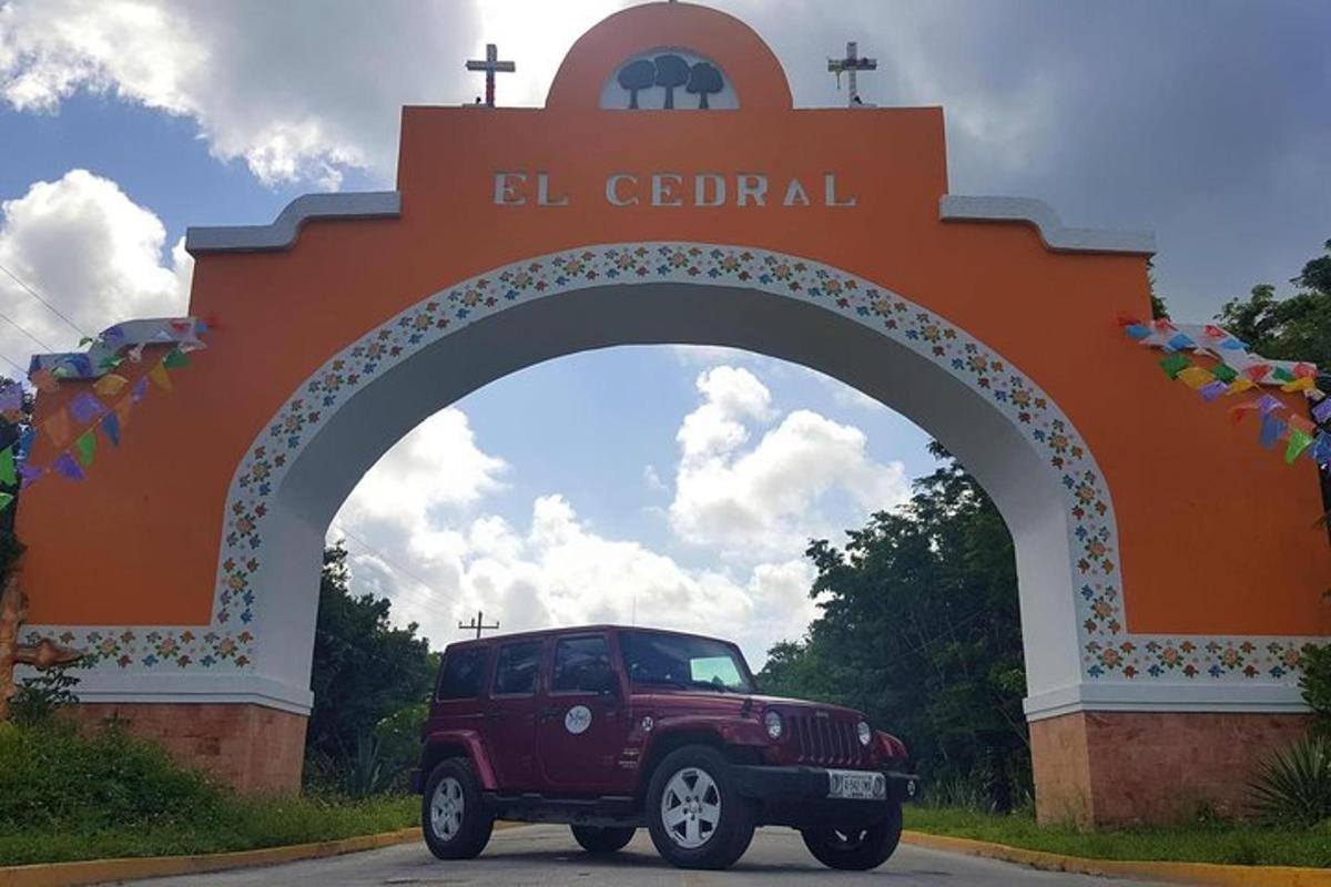 una jeep color castagna parcheggiata davanti a un cancello