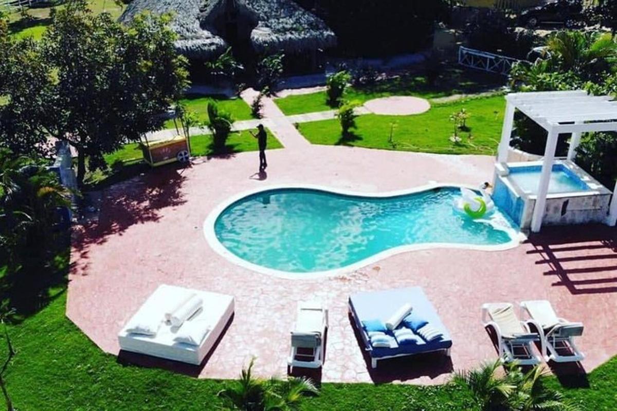 an overhead view of a swimming pool with chairs and a gazebo