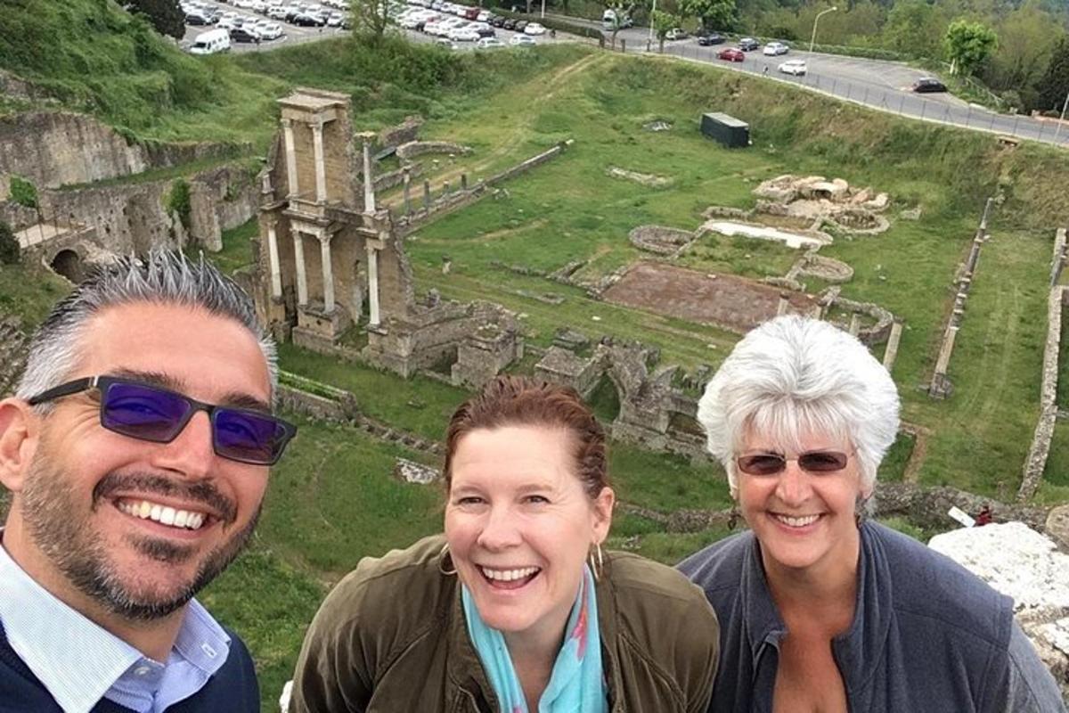 Tres personas posando para una foto frente a las ruinas.