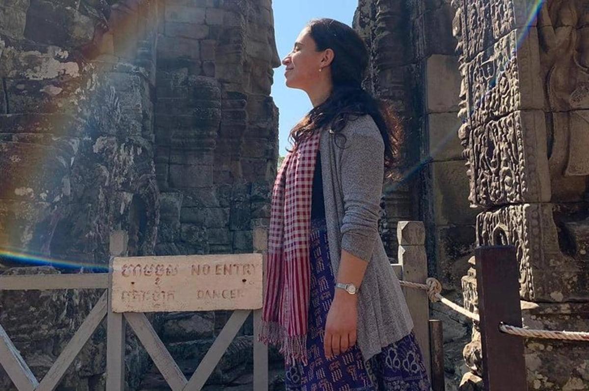 eine Frau steht neben einer Wand mit einem Regenbogen