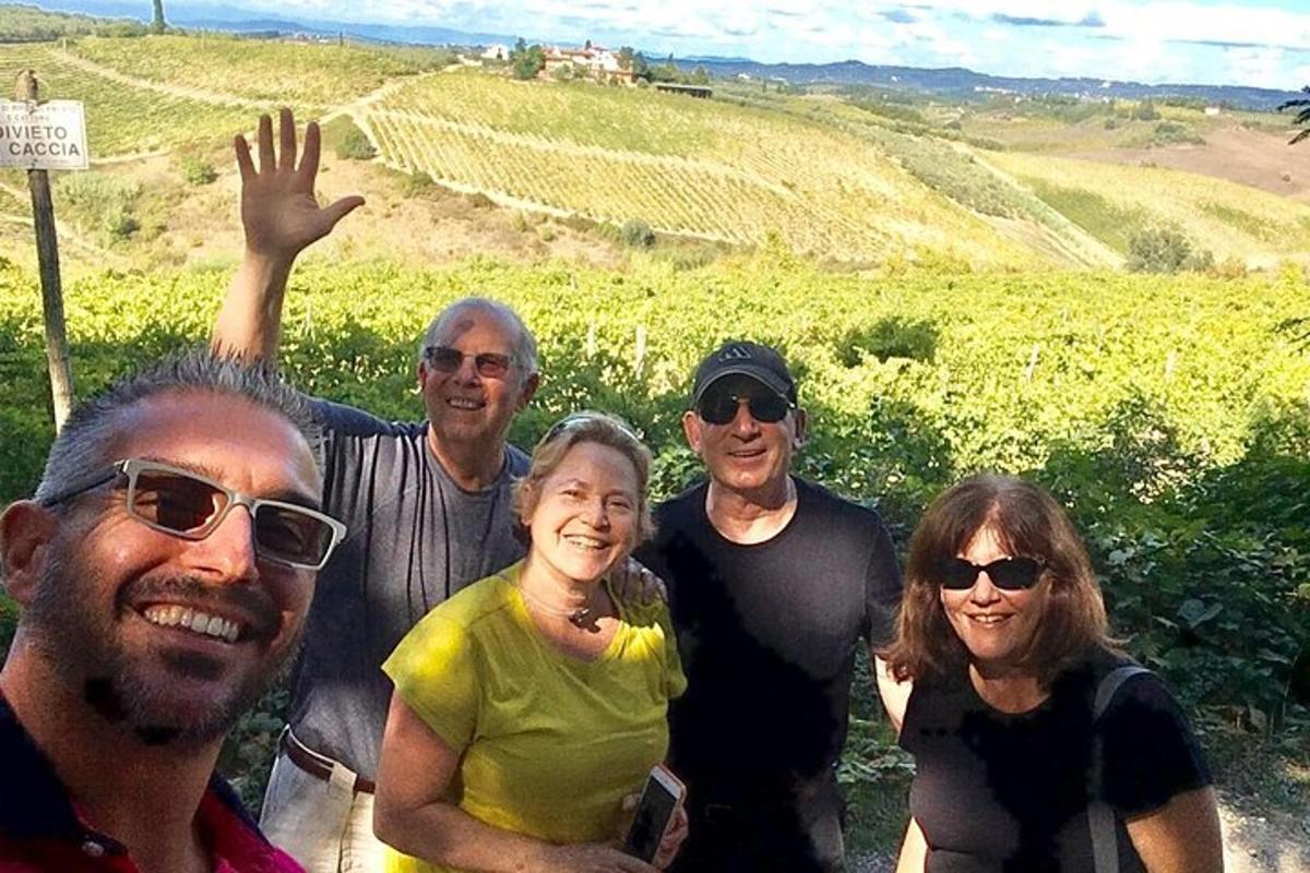 Un grupo de personas posando para una foto en un viñedo.