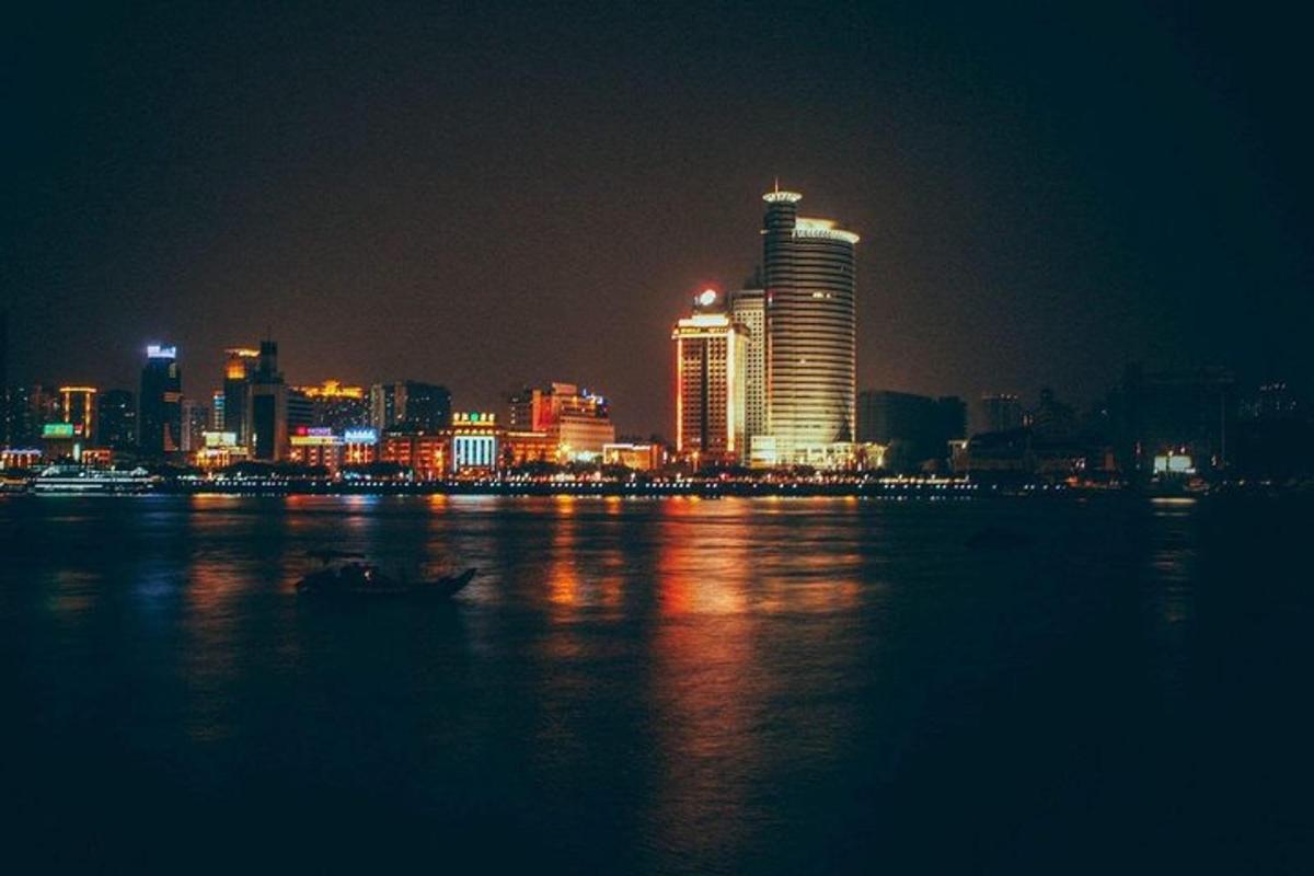 夜晚的城市天际线，水中有一艘船