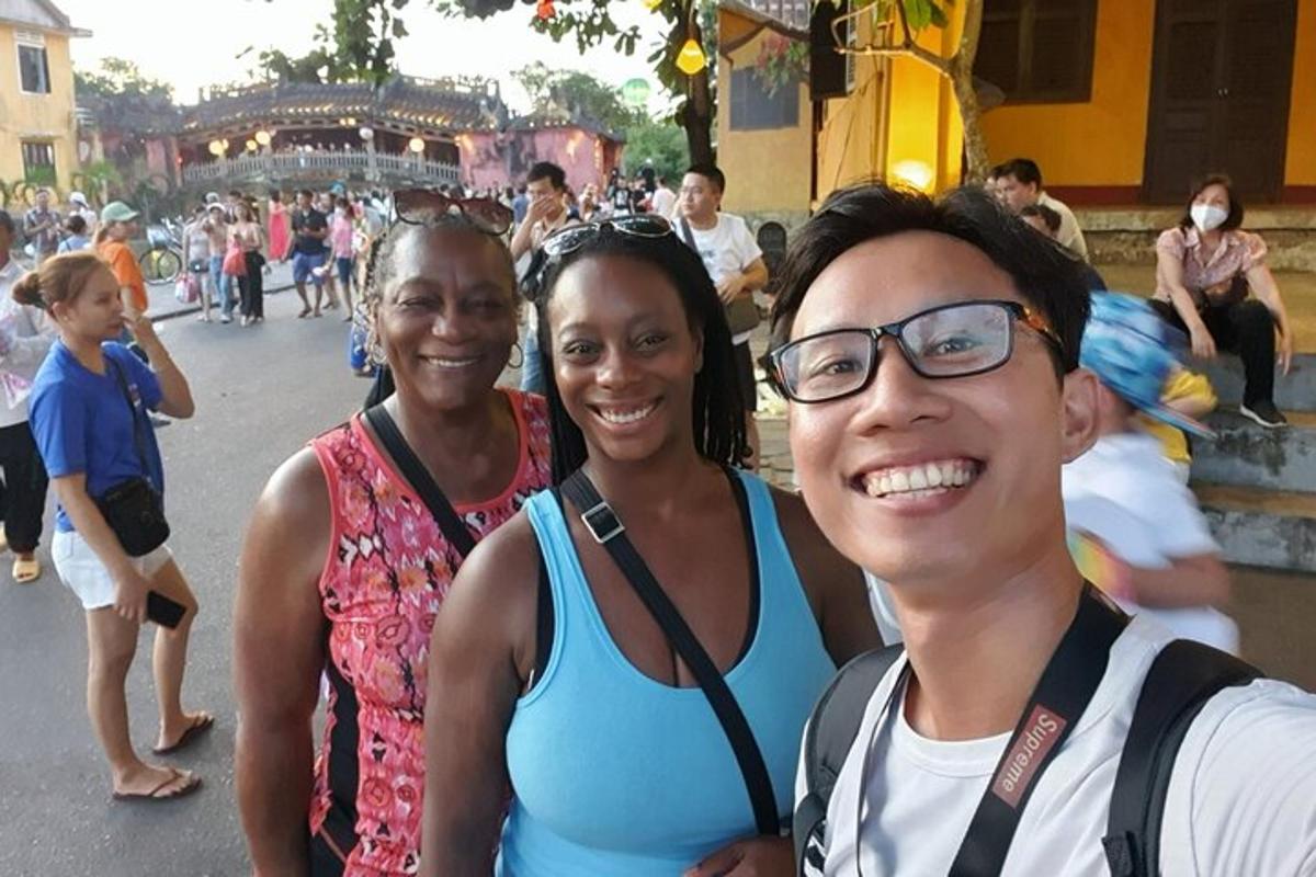 tre persone posano per una foto in strada