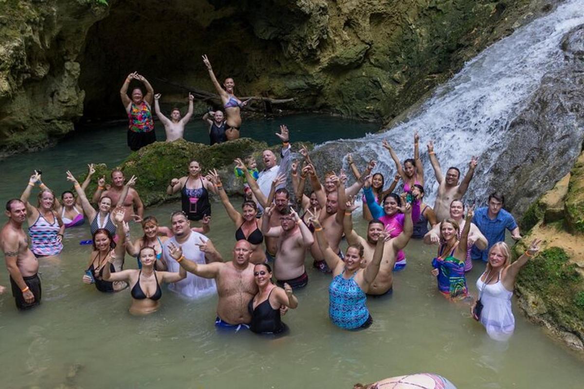 un gruppo di persone in acqua vicino a una cascata
