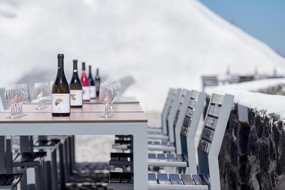 o masă cu sticle de vin și pahare pe o pervaz