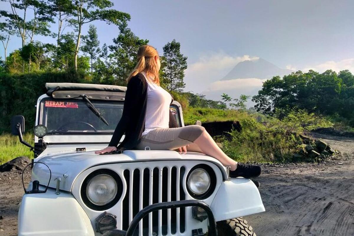 en kvinne som sitter på panseret på en jeep