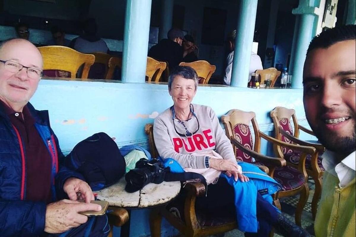 двоє чоловіків і жінка сидять на стільцях з камерою