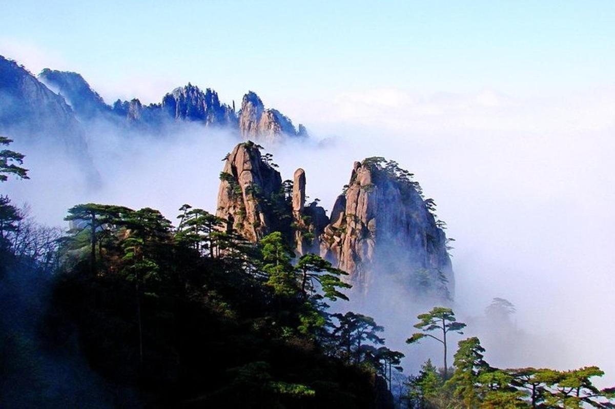 a mountain rising out of the fog in the mountains