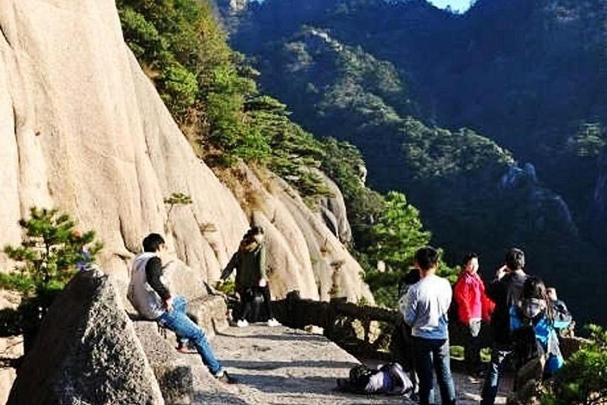 a group of people standing on the side of a mountain