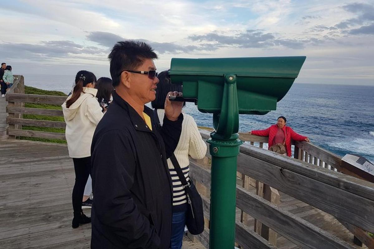 muž fotografující oceán fotoaparátem