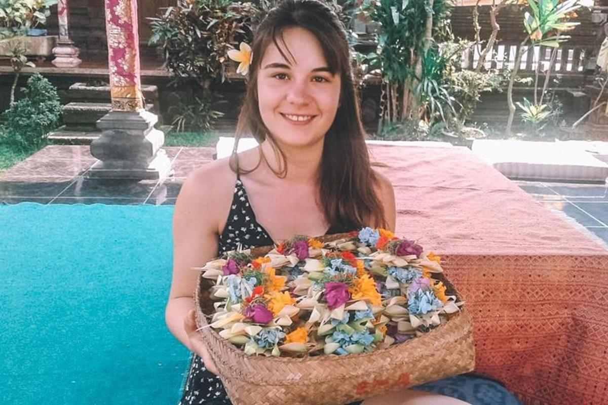 a woman is holding a basket of flowers