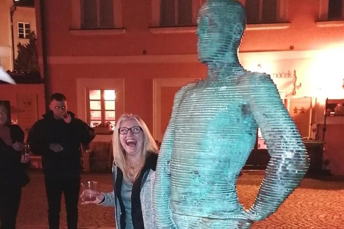 Μια γυναίκα που στέκεται δίπλα σε ένα γυάλινο γλυπτό