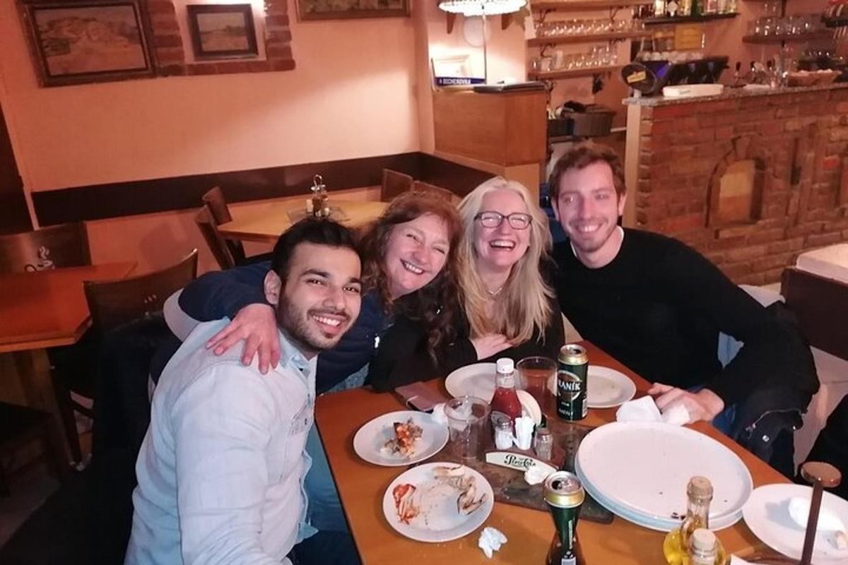 een groep mensen die aan een tafel in een restaurant zitten