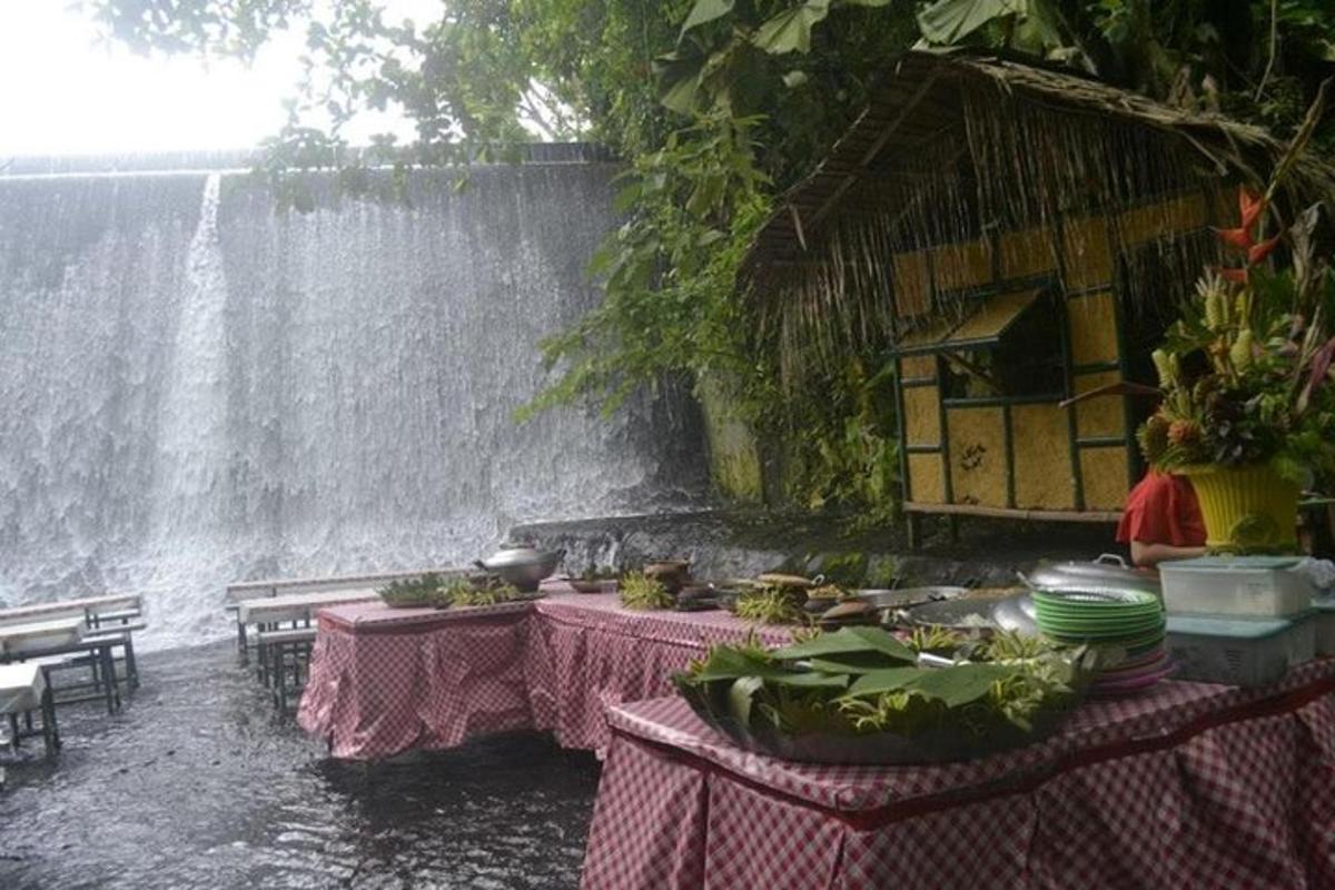 a waterfall with two tables in front of a fountain