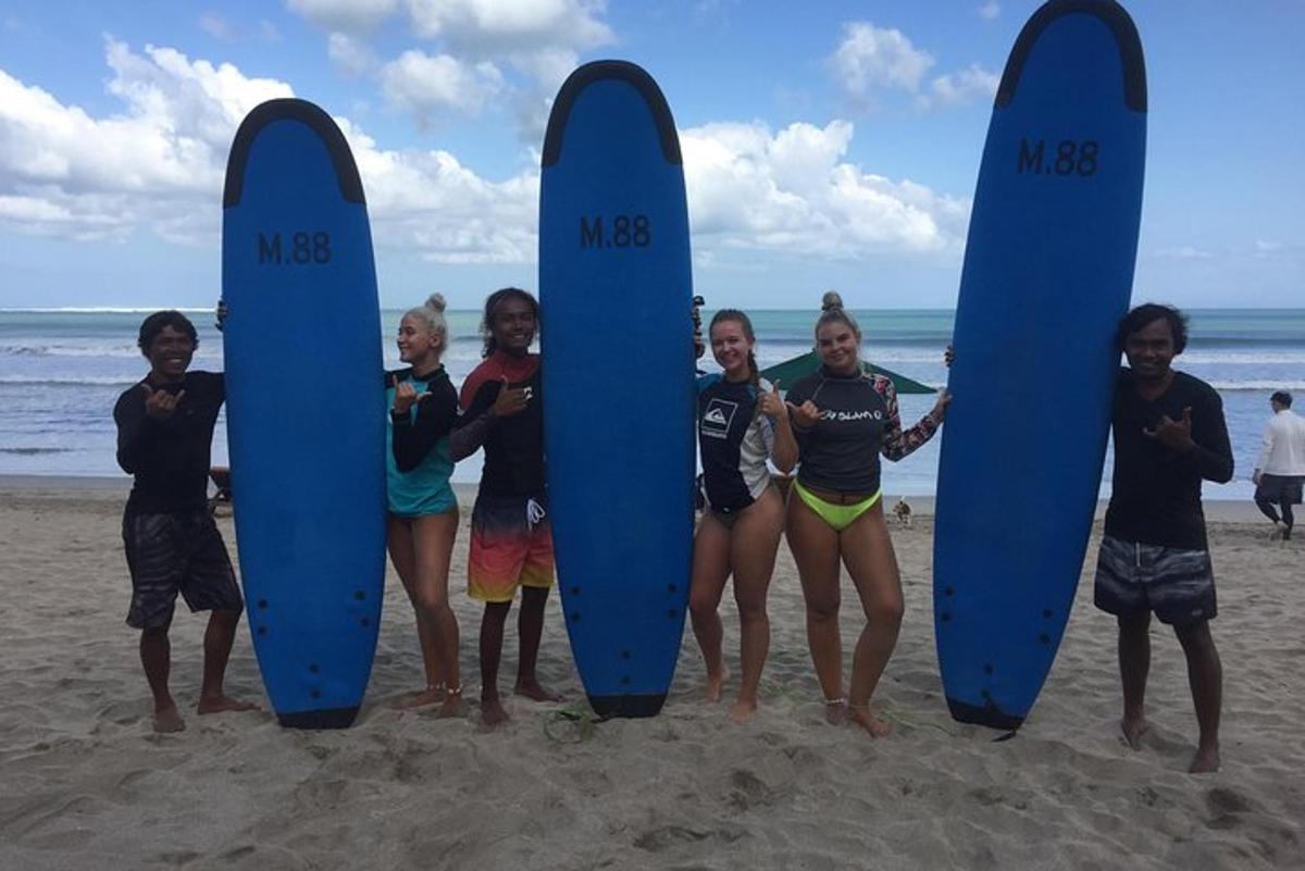 a group of children standing on the beach with surfboards
