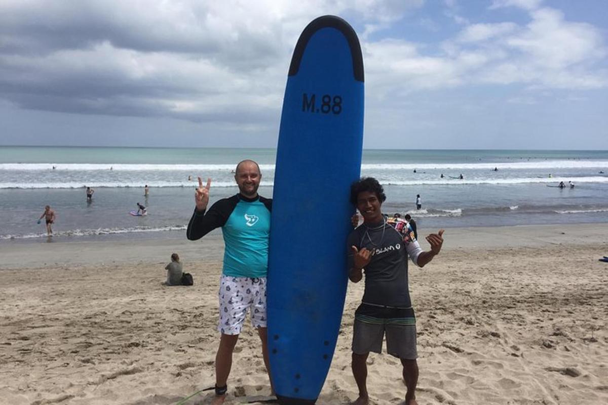 a man and a boy holding a surfboard on the beach