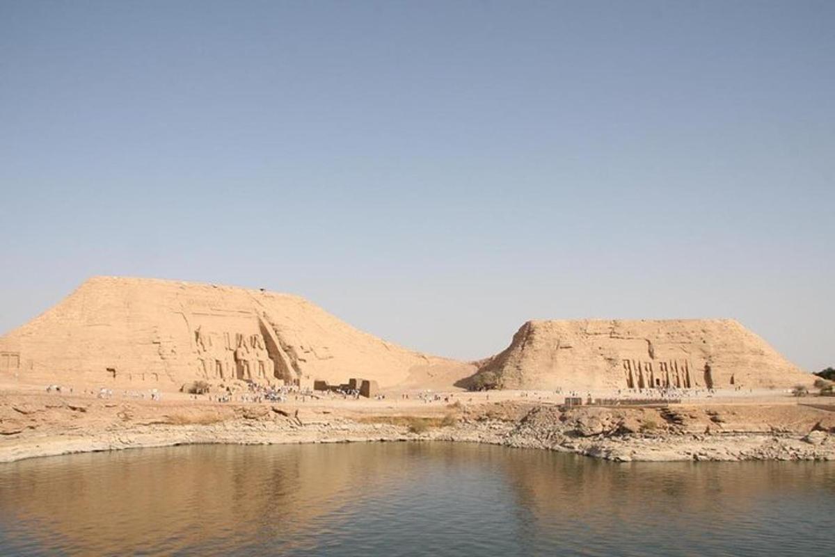 two large sand hills next to a body of water