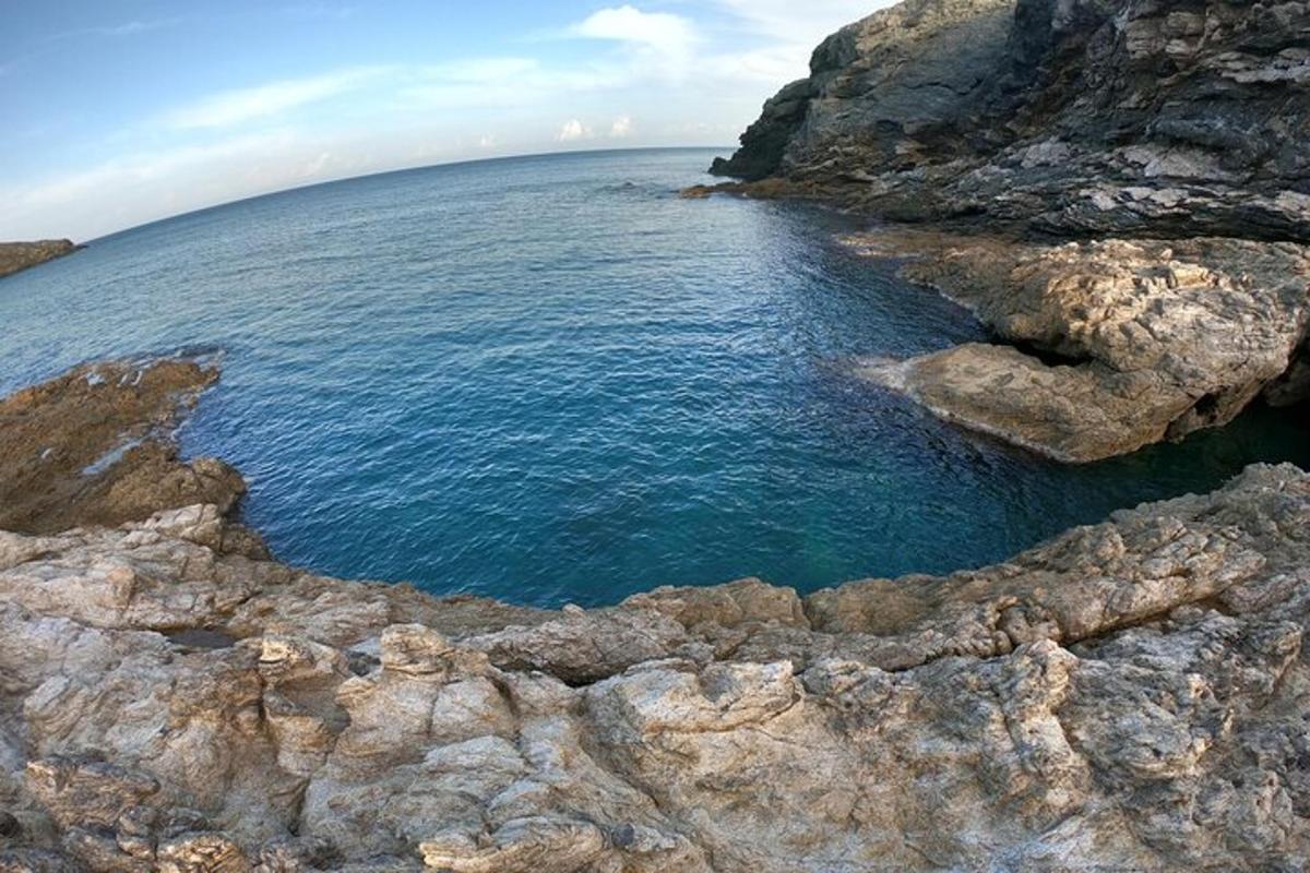 un grande specchio d'acqua accanto ad alcune rocce