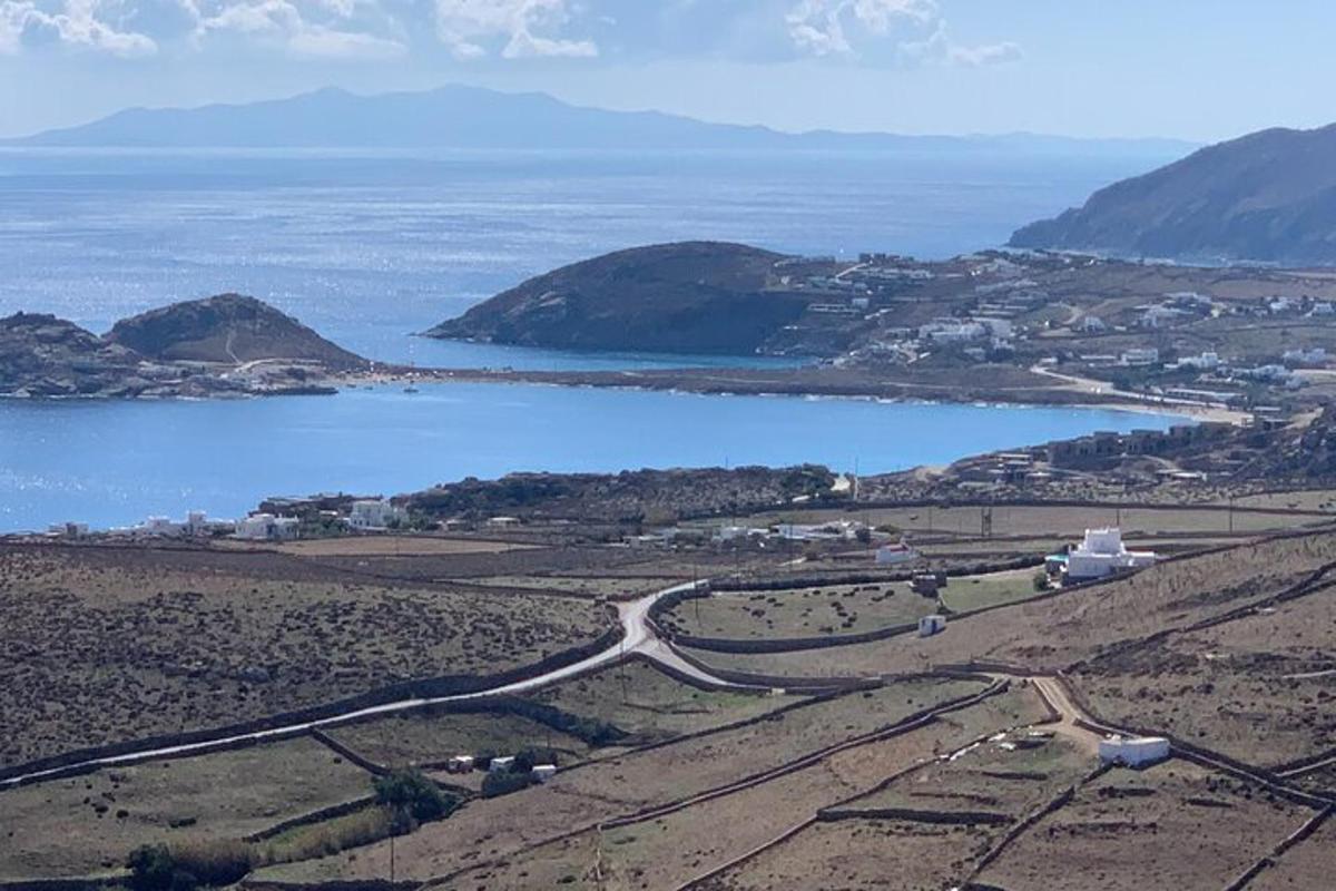 una strada in un campo vicino a uno specchio d'acqua