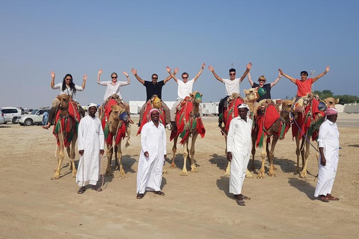 a group of people riding on the backs of camels