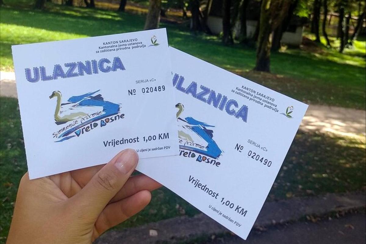 oseba, ki drži dve vstopnici za ptičjo razstavo