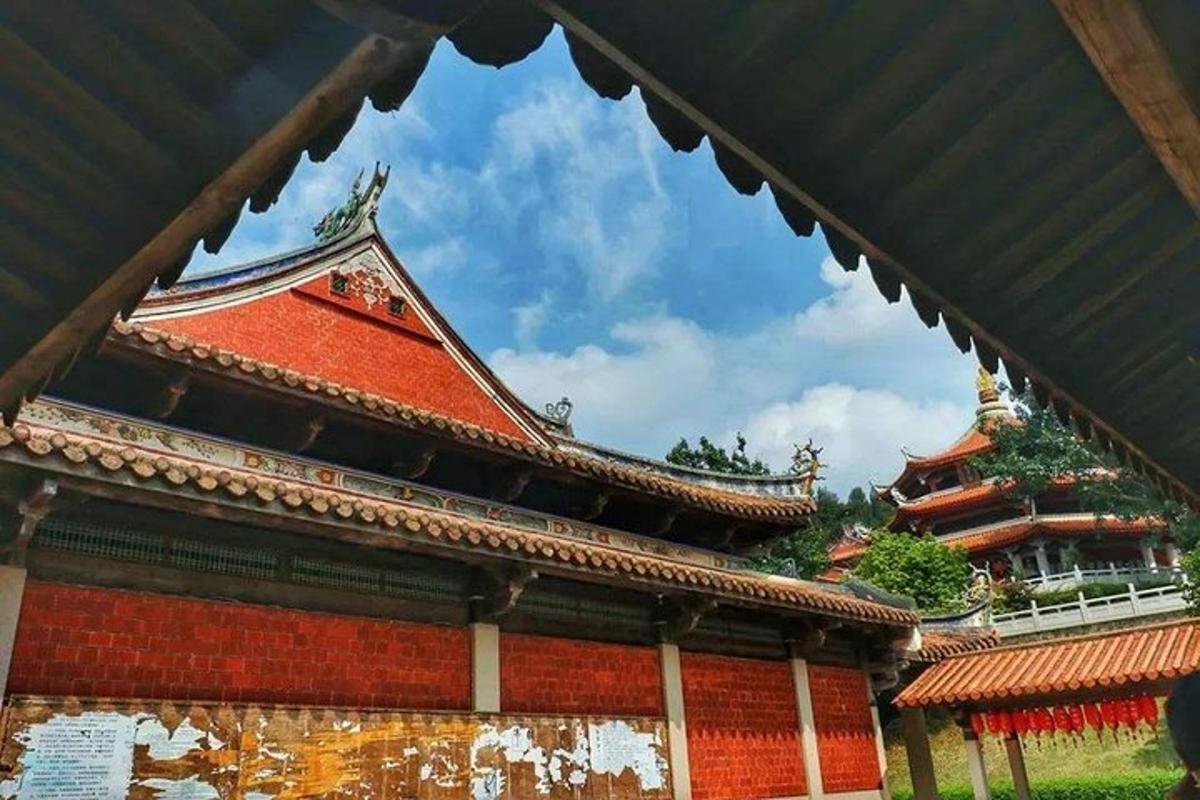 a building with a red roof with a building in the background