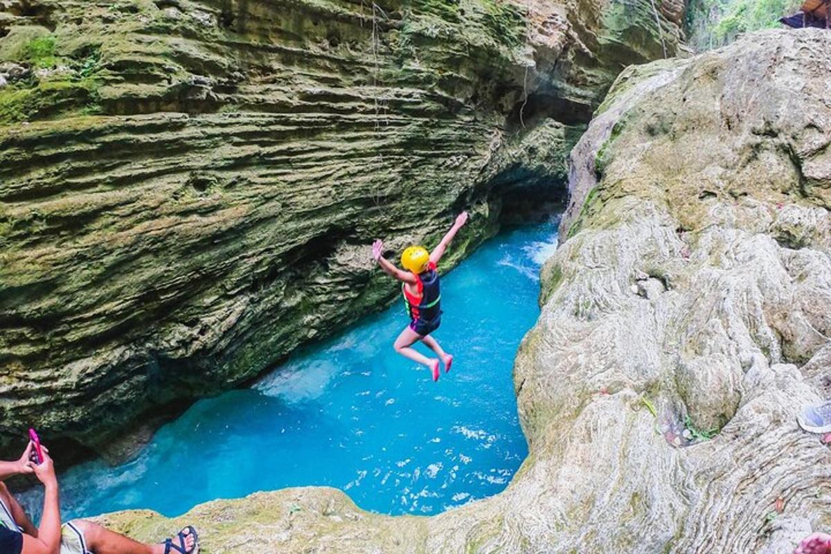 un uomo che salta in un fiume in una grotta